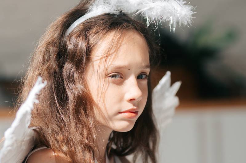 Primer plano de una niña disfrazada de ángel.
