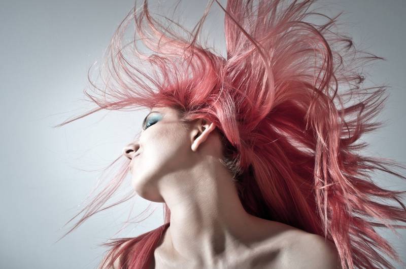 Mujer con el cabello rosa al viento.