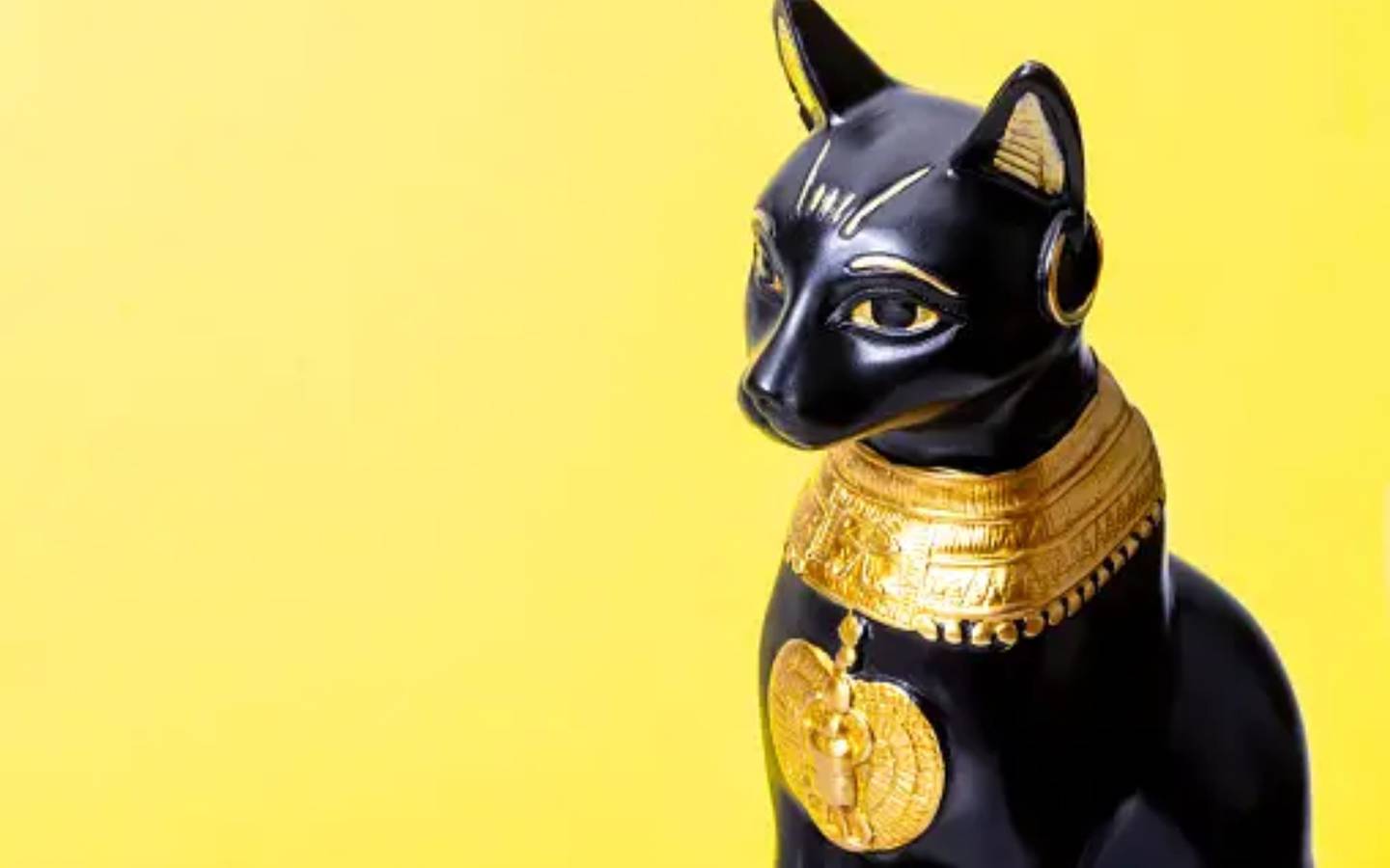 Figura de un gato egipcio sobre un fondo amarillo - qué significa soñar con gatos