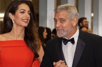 George Clooney ayuda a su esposa Amal a posar como una rockstar de las alfombras rojas