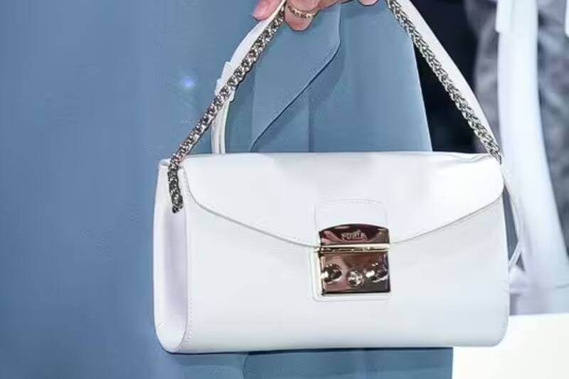 Letizia llevó su bolso Furla. Confeccionado por expertos en cuero, este icónico bolso Metropolis blanco presenta una correa para el hombro con cadena en tono dorado