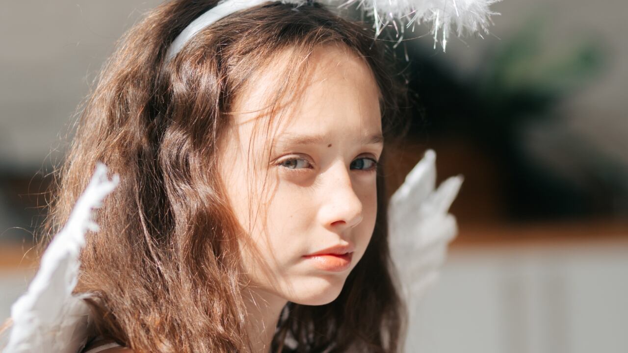 Primer plano de una niña disfrazada de ángel.
