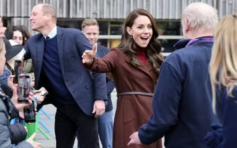 El príncipe de Gales saluda a la multitud mientras que Kate extiende sus brazos para abrazar a su ex maestro.