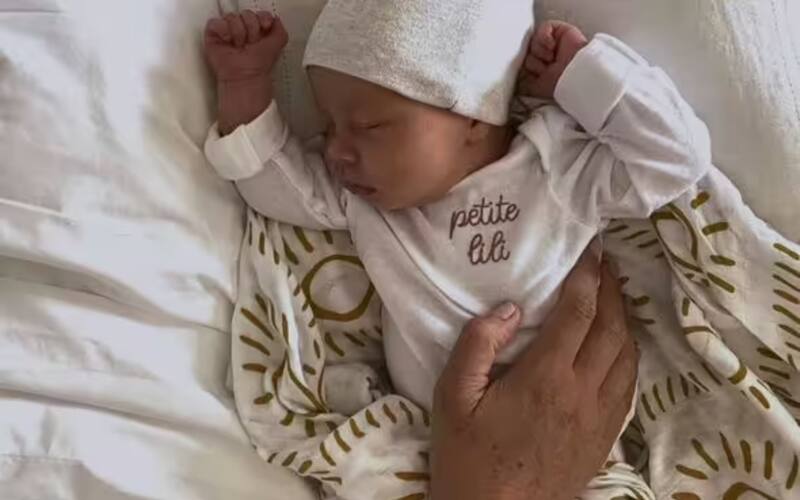 La princesa Lilibet Diana recién nacida descansa sobre su cama.